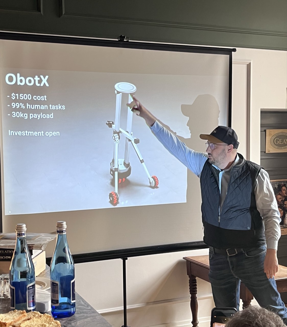 Śniadanie Robotyczne — Prelegent wskazuje robota ObotX przy slajdzie